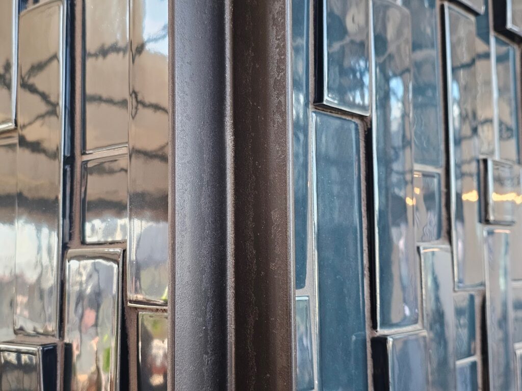 the planar surfaces of the tile wall