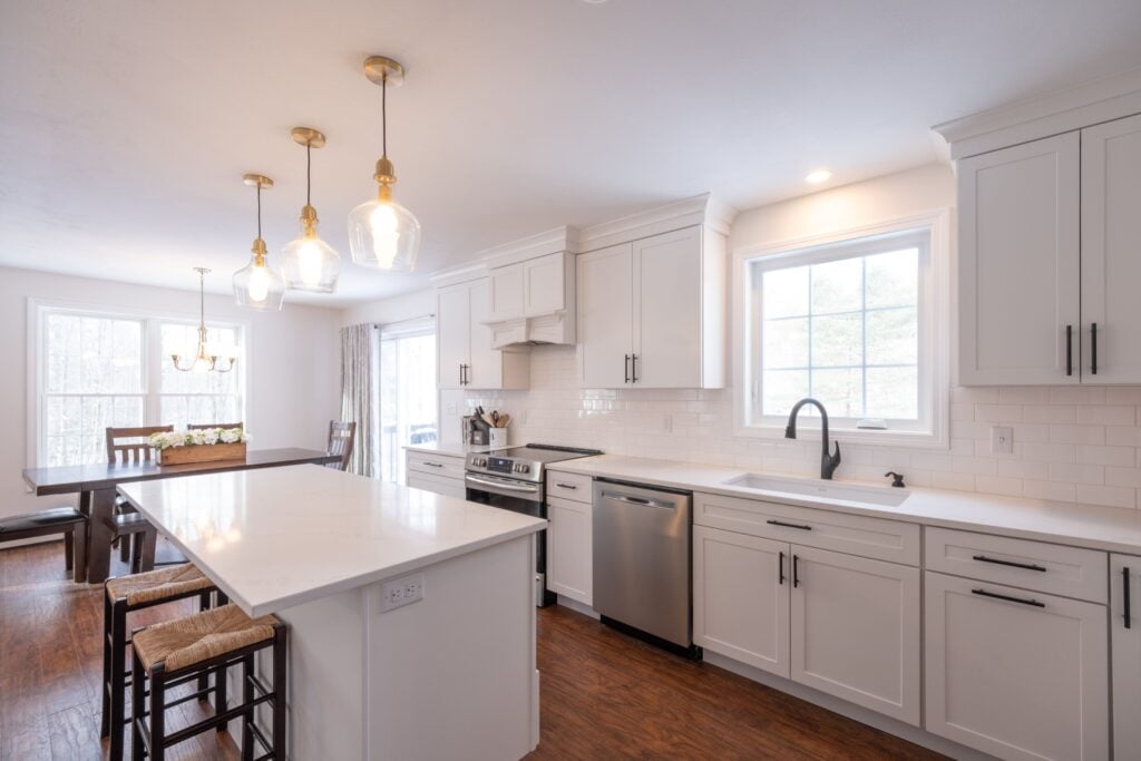 Kitchen with the main sink on the wall under a window and a separate island with seating