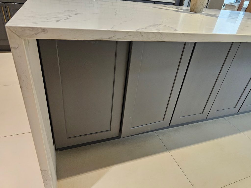 Grey Cabinets with white backsplash and sleek hardware