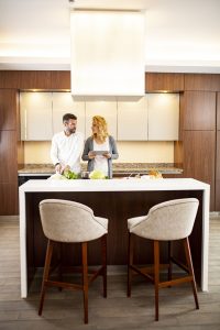 Young couple cooking in the modern kitchen and using digital tablet