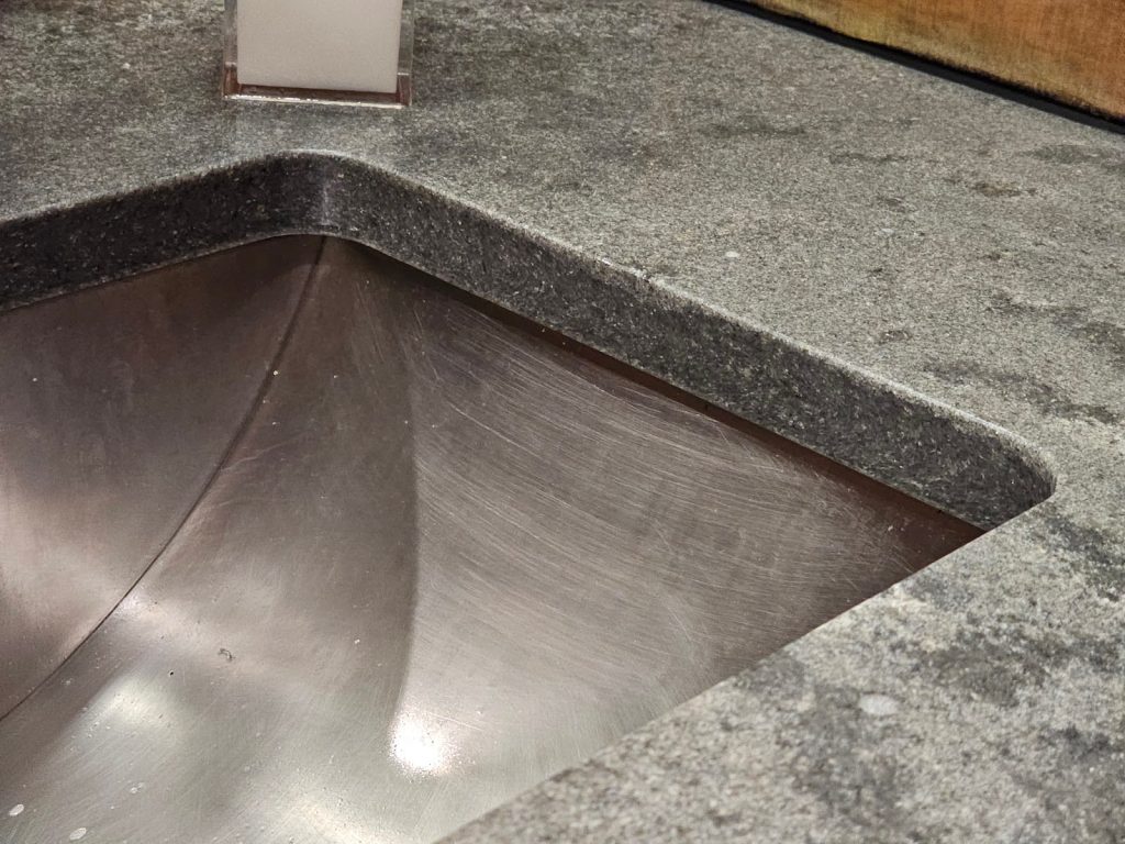 dark gray countertop has been caulked to the wall