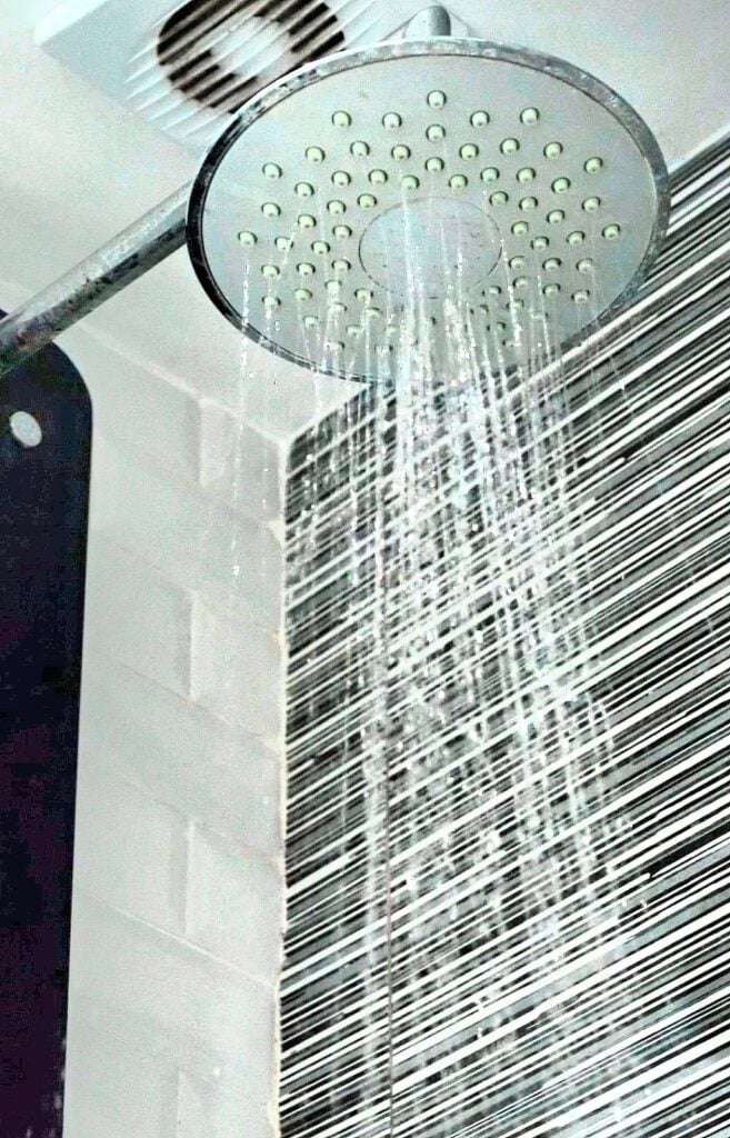 Close-up of rain shower head and temperature control panel setup