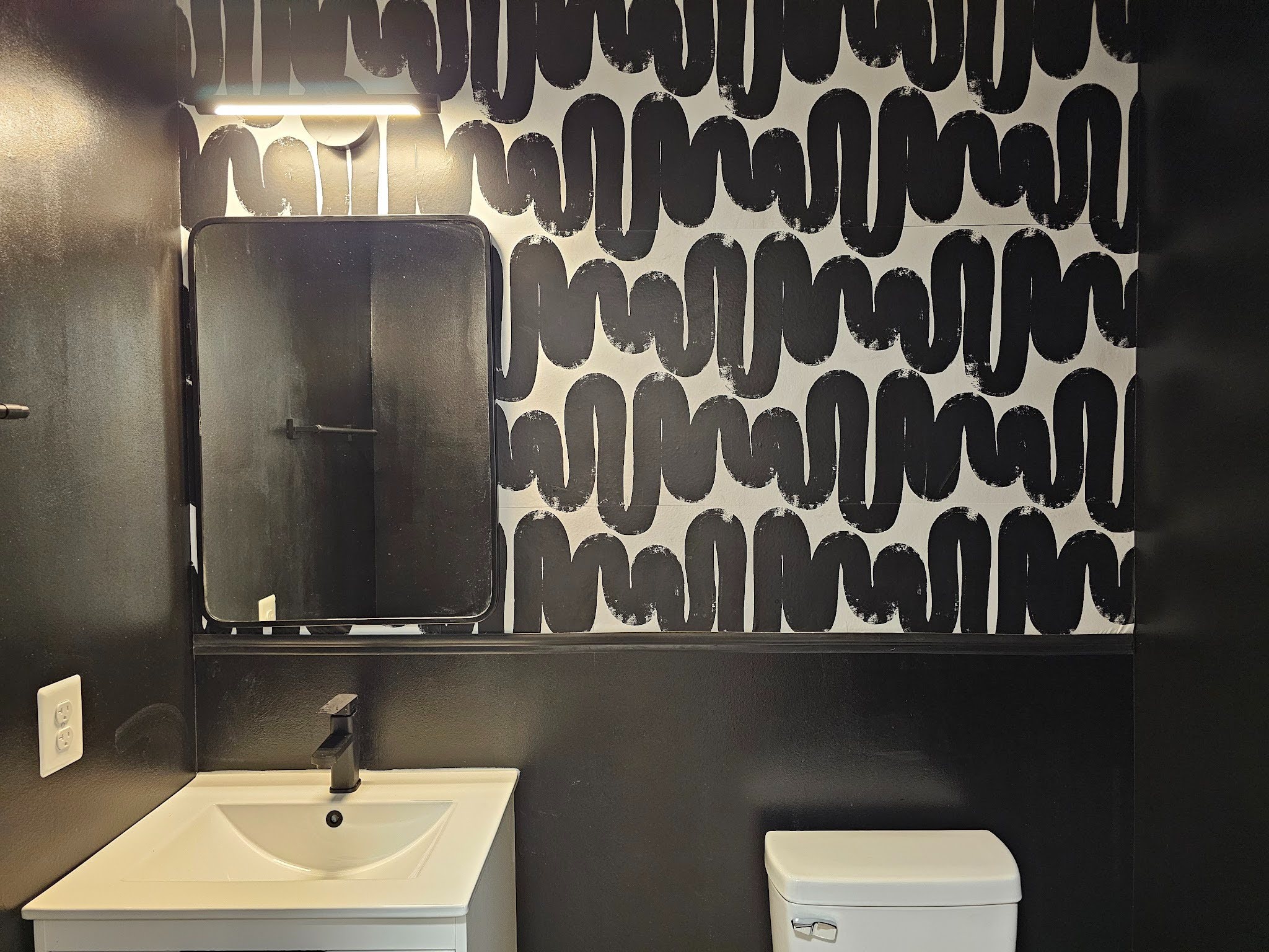 Modern bathroom featuring a stylish wiggle-pattern accent wall design