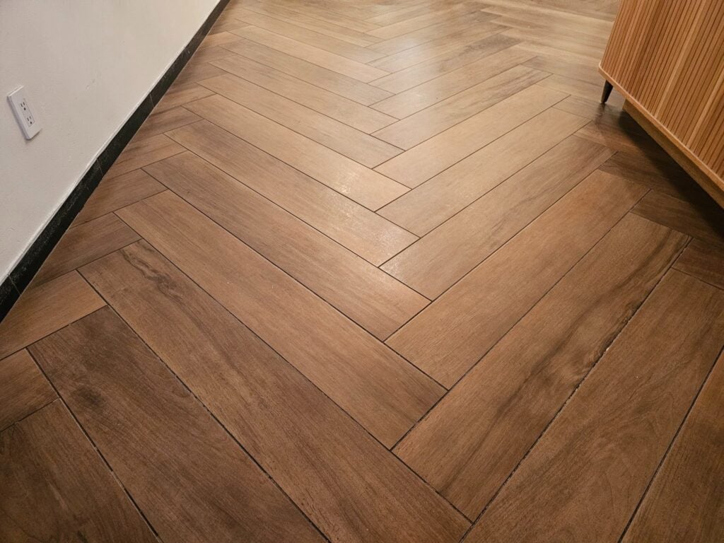 Beautiful herringbone pattern wood-like tile floor combining durability with natural wood aesthetics