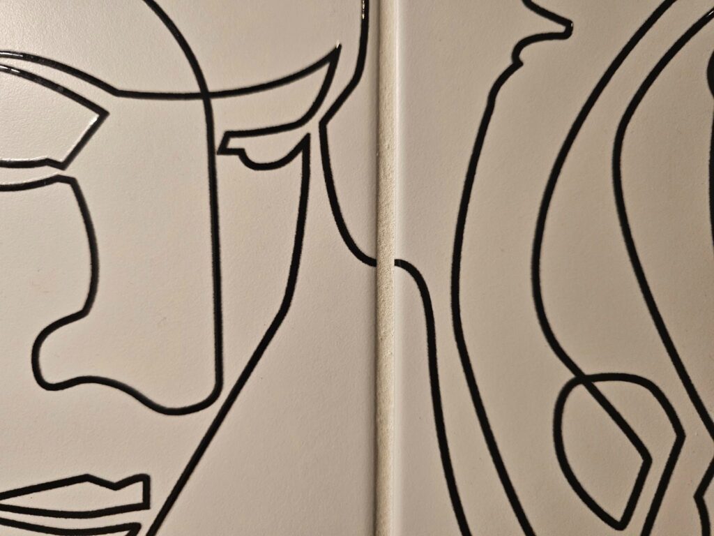 Close-up of porcelain wall tile with single-line art design