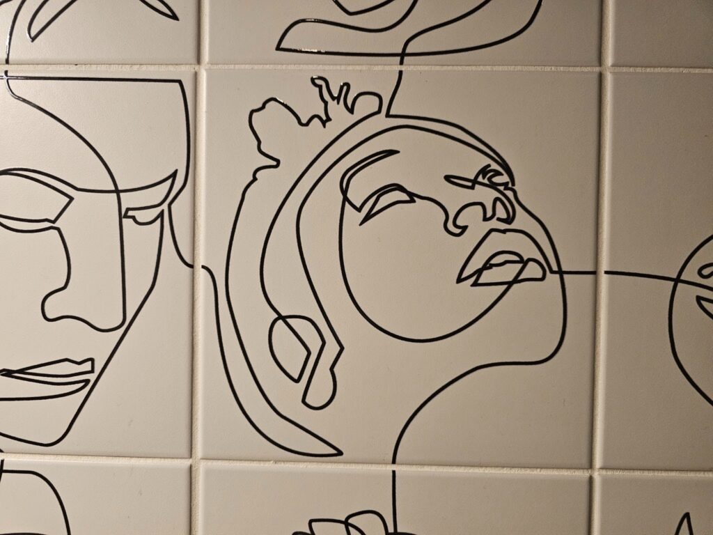 Detailed view of single-line artwork on porcelain wall tile