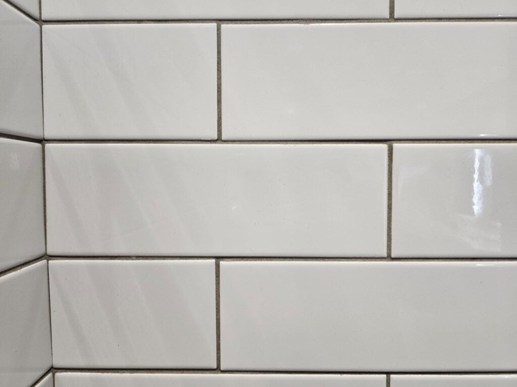 Bathroom featuring clean white subway tile installation